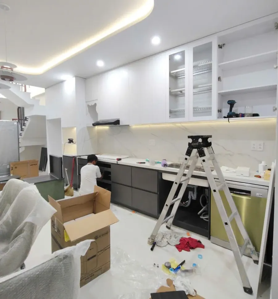 Hệ tủ bếp được đưa vào vị trí, cân chỉnh và liên kết trước khi kiểm tra cánh tủ, ngăn kéo và các chi tiết hoàn thiện.