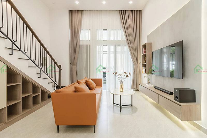Phòng khách nhà phố phong cách minimalism, với gam màu trung tính, nội thất đơn giản nhưng tinh tế, tạo không gian rộng rãi và thoáng mát.