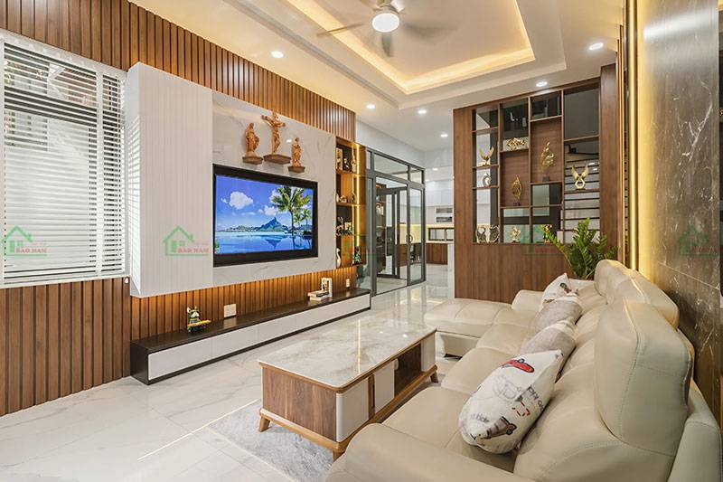 Phòng khách hiện đại với bộ sofa màu kem, tạo điểm nhấn với hệ thống ánh sáng và các chi tiết trang trí tinh tế.