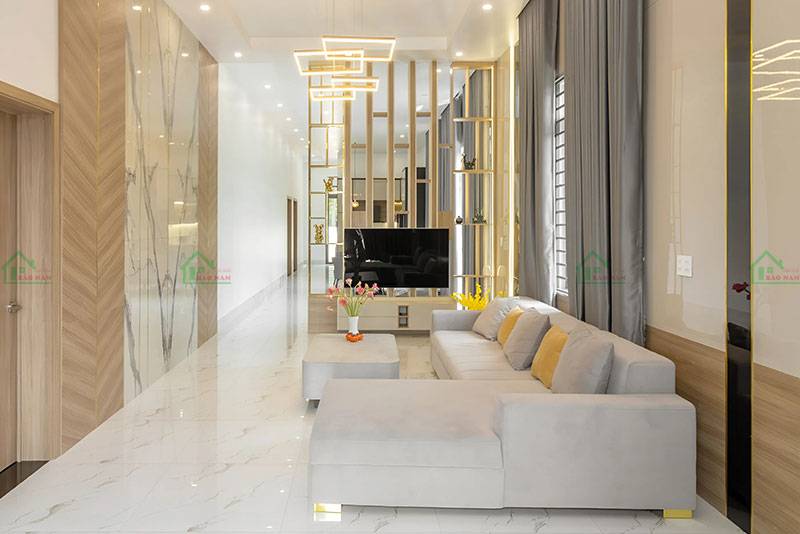 Phòng khách rộng rãi và sang trọng với bộ sofa màu xám nhạt, được thiết kế theo phong cách hiện đại